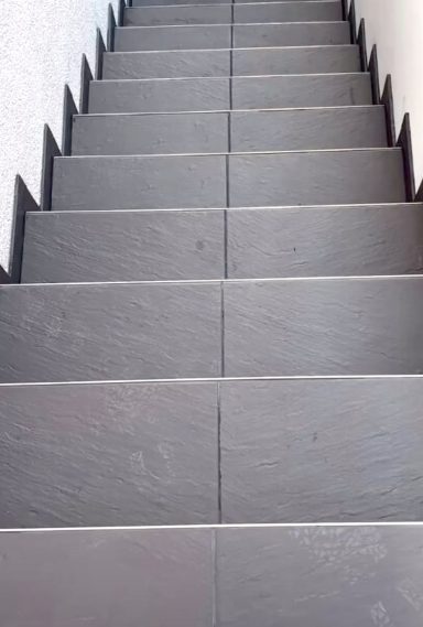 Helle Treppe mit dunklen Kanten, die sich nach unten erstreckt.