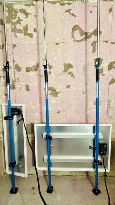 Wasserschaden Trocknungsgeräte Zwei verstellbare Stützstangen in Blau mit einer silbernen Platte im Hintergrund.